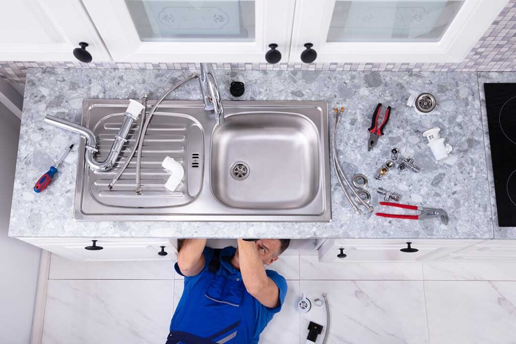 Person adjusting a toilet tank float while inspecting the flapper and water level.