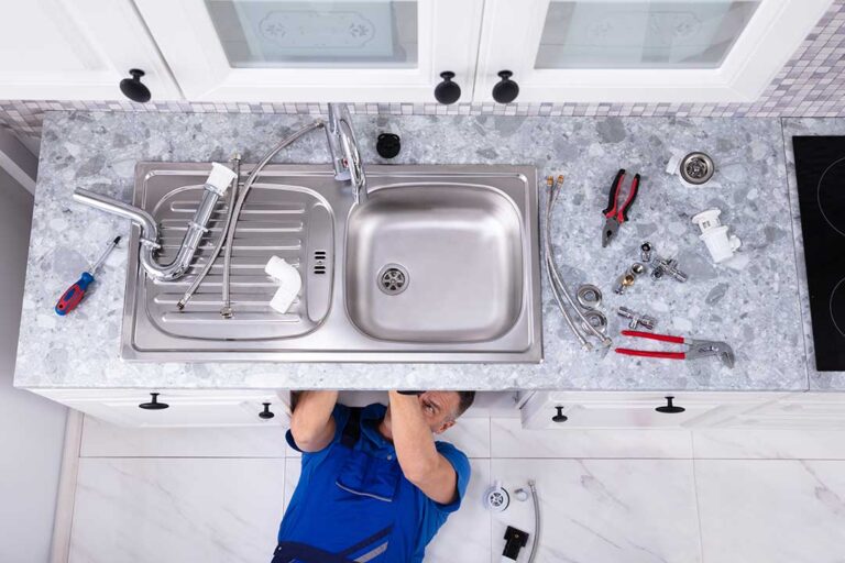 Person adjusting a toilet tank float while inspecting the flapper and water level.